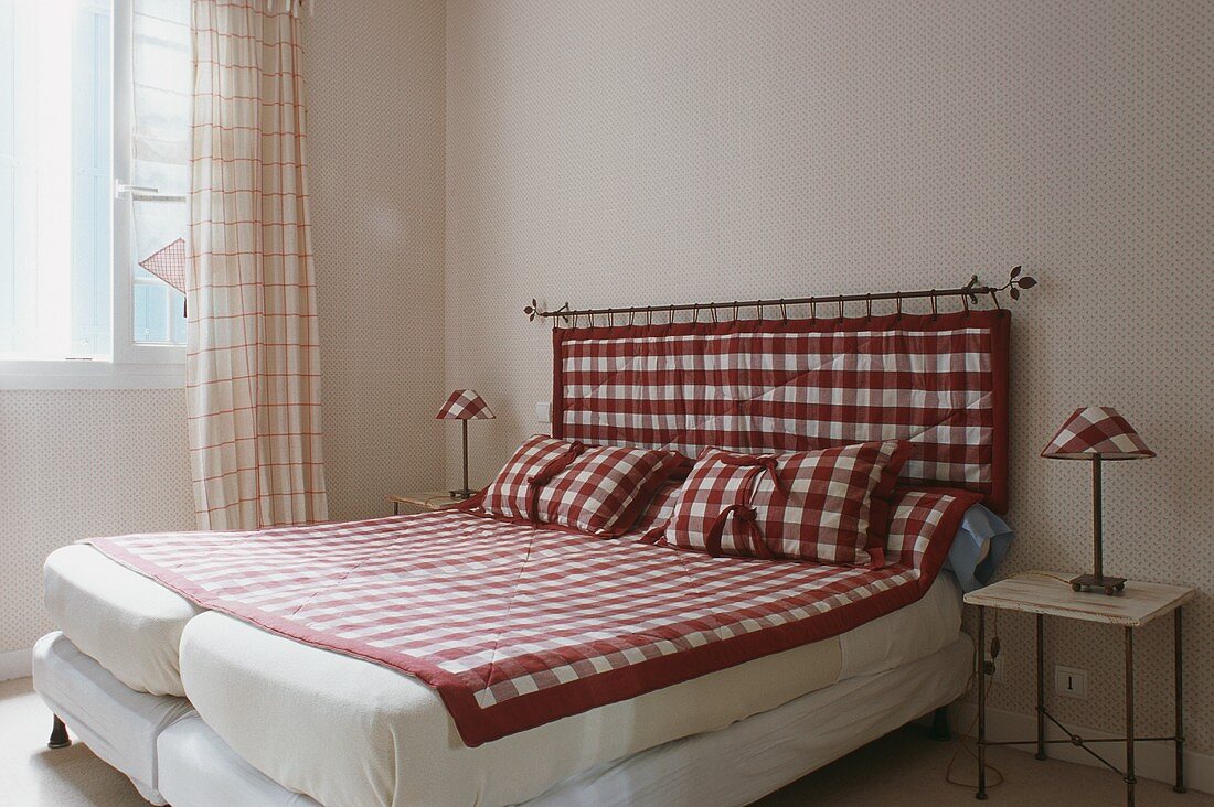 Two beds next to each other with a red and white checked quilt