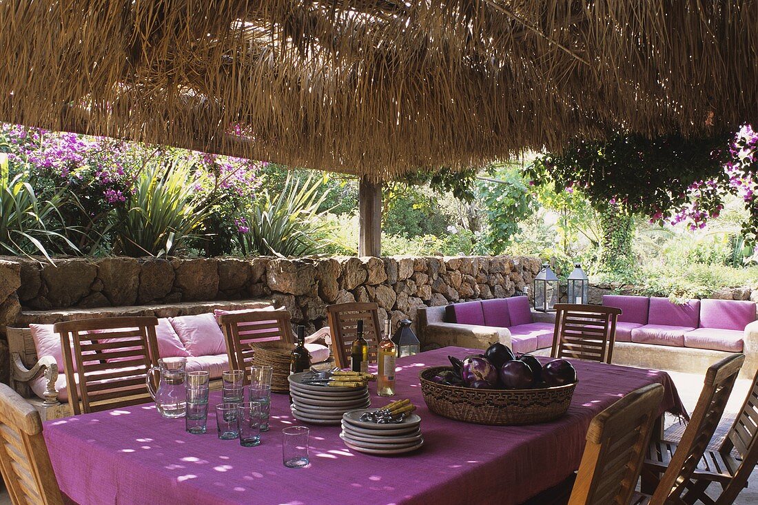 Ein Esstisch auf einer überdachten Terrasse (Pantelleria, Sizilien, Italien)
