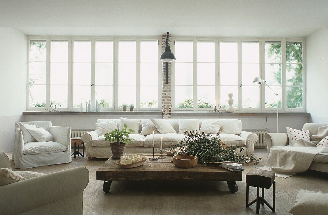 A light coloured living room with a low wooden table in a loft