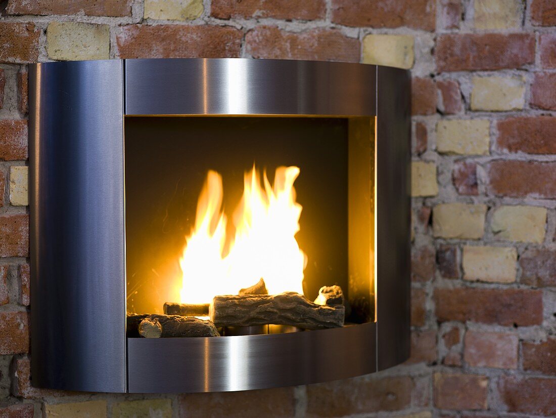 Stainless steel frame around a fireplace with a fire