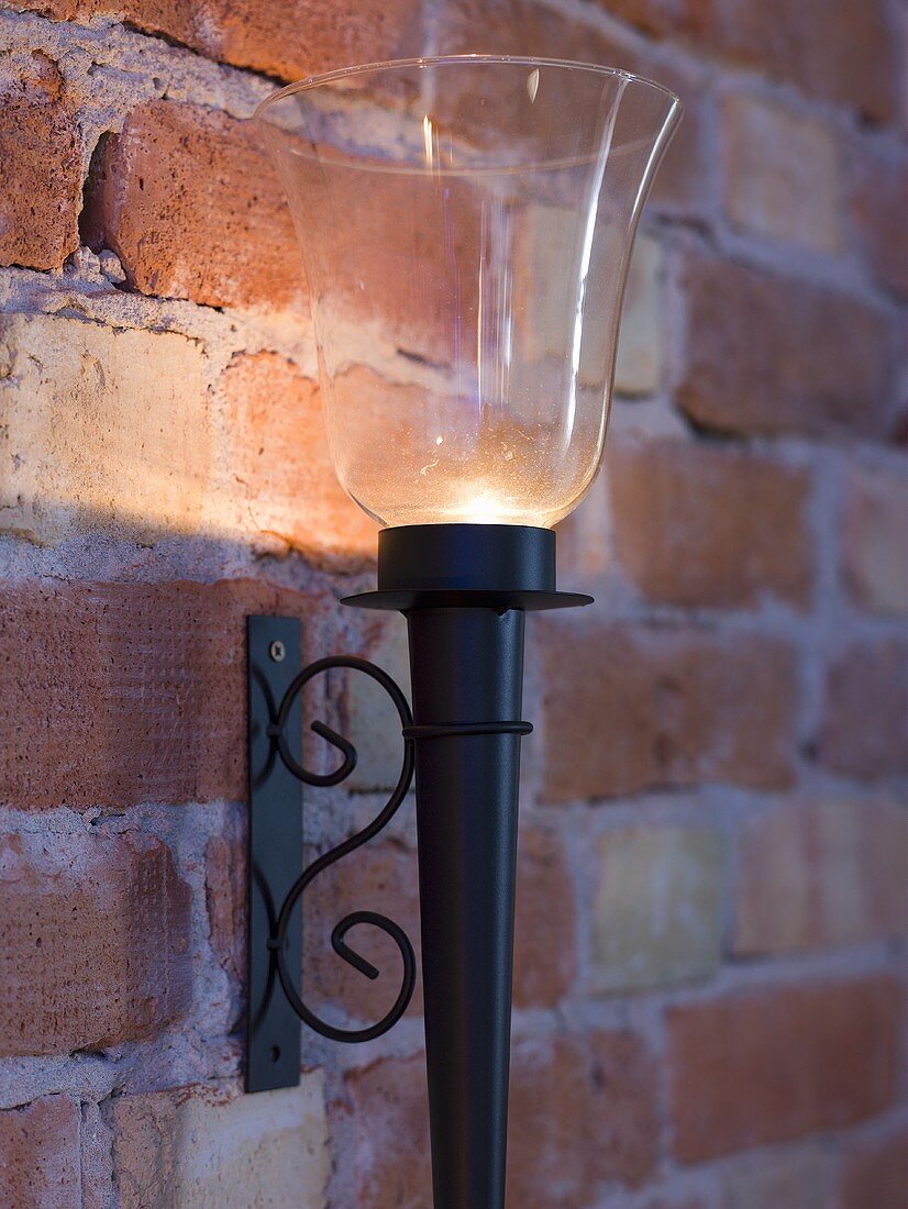Candles wall sconces with glass shades on a brick wall