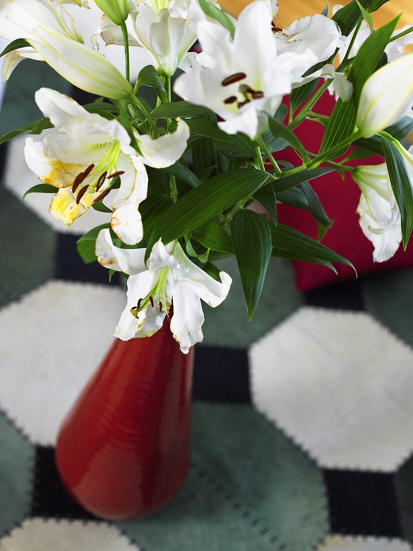 weiße Lilien in roter Vase