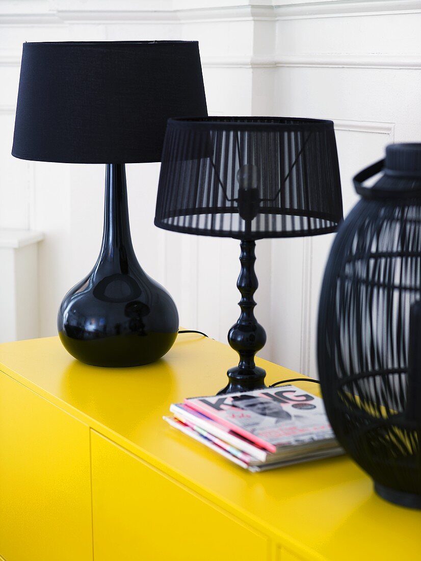 Black table lamps on a yellow cabinet