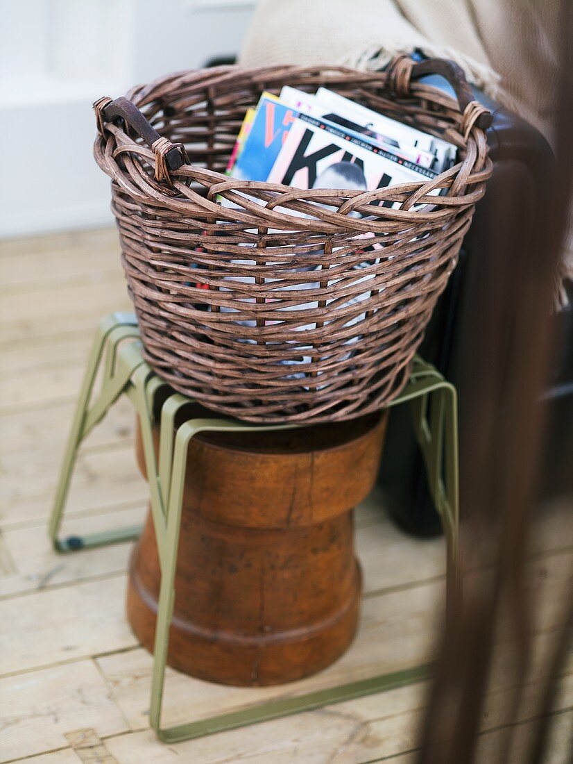 Wicker basket with magazines on a metal stool