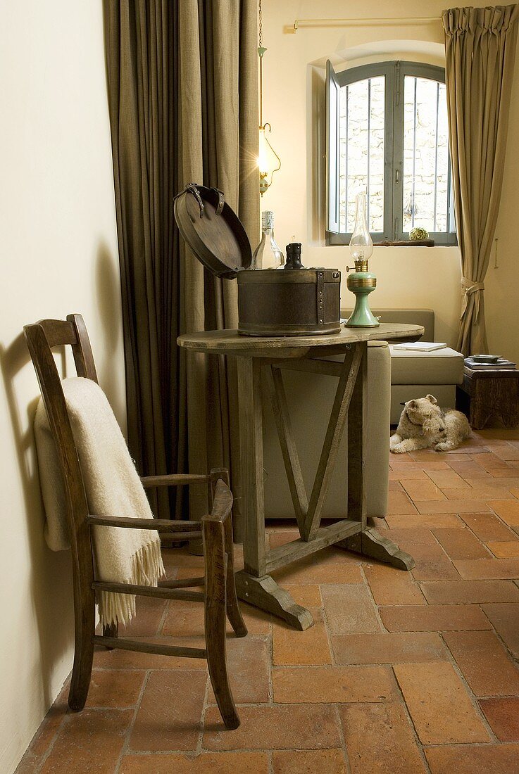 Corner of a living room and an old country house with an old chair and side table on a terracotta floor