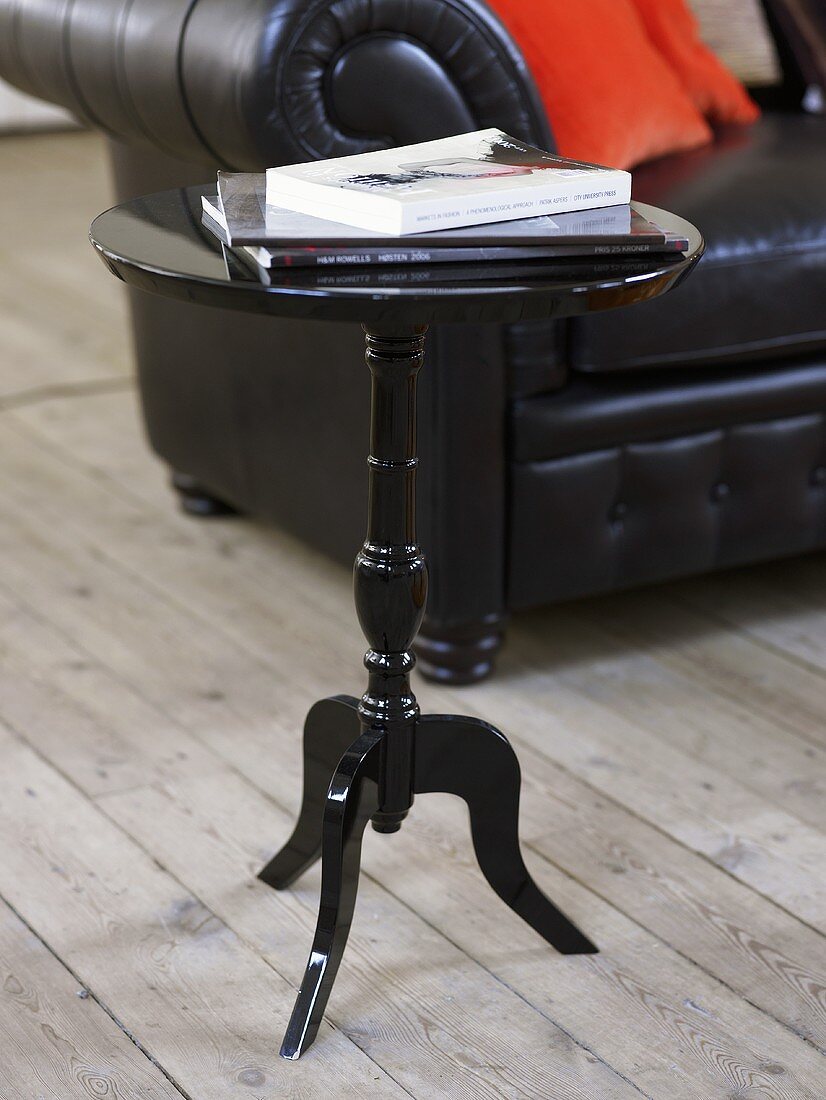 Black side table in front of a leather sofa