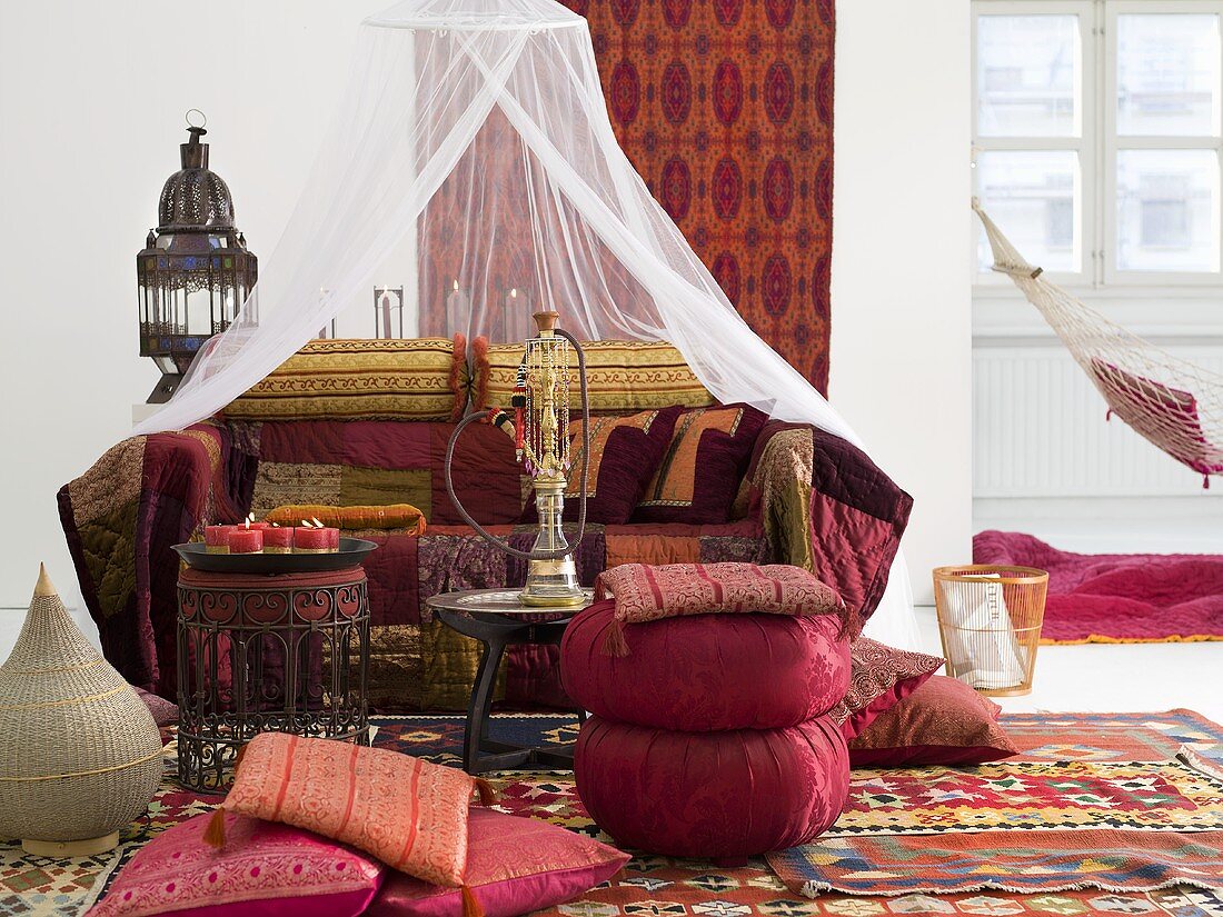 Oriental-themed sitting area with cushions around a side table and hookah