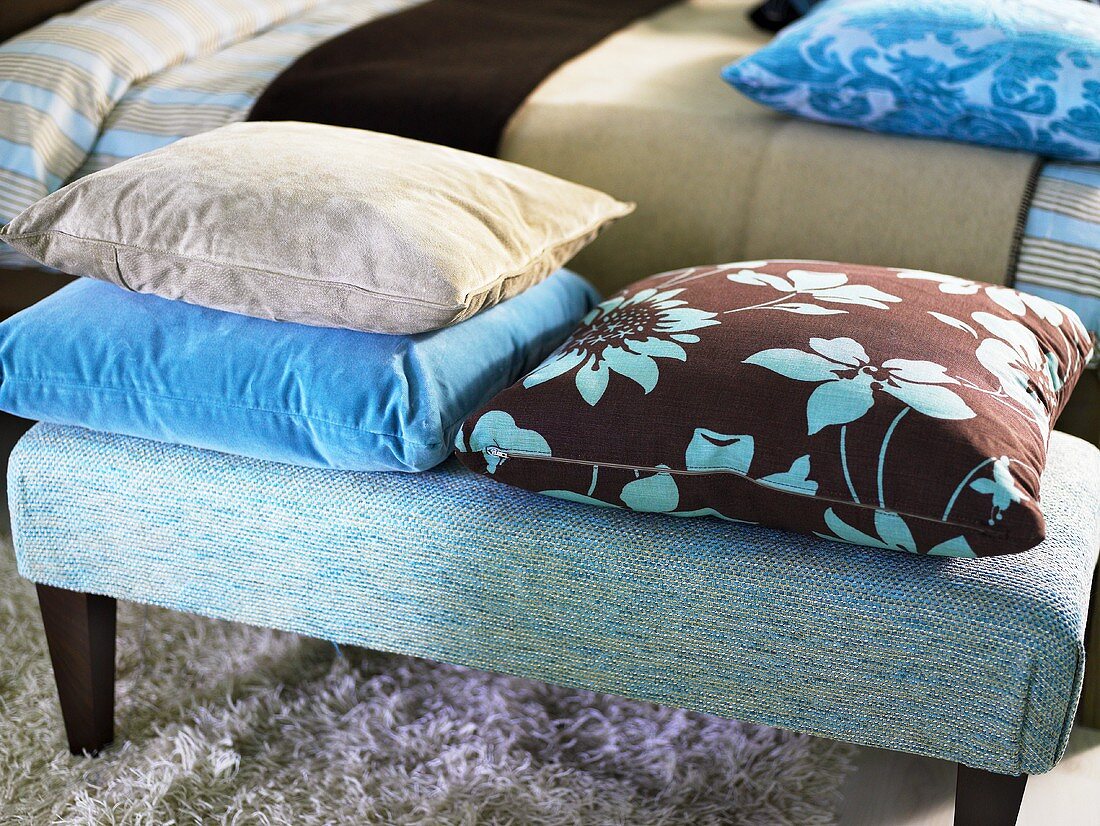 Solid color and patterned pillows on an upholstered bench