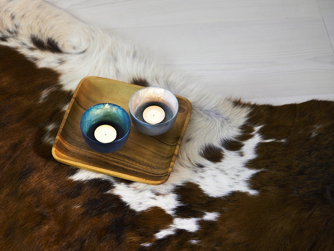 Wooden dish with tea lights on a hide