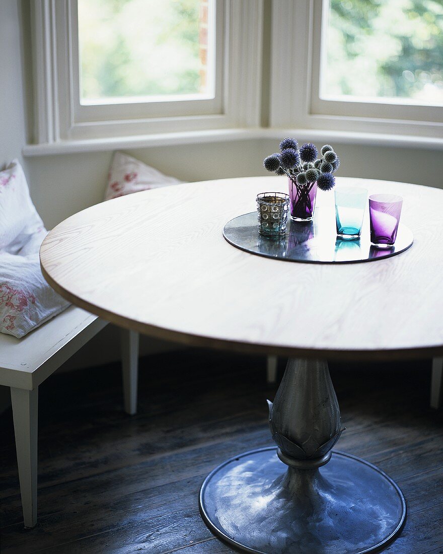 A round table in front of a window seat