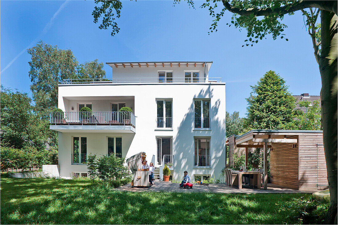 Mutter und zwei Kinder auf der Terrasse von einem Einfamilienhaus, Hamburg, Deutschland