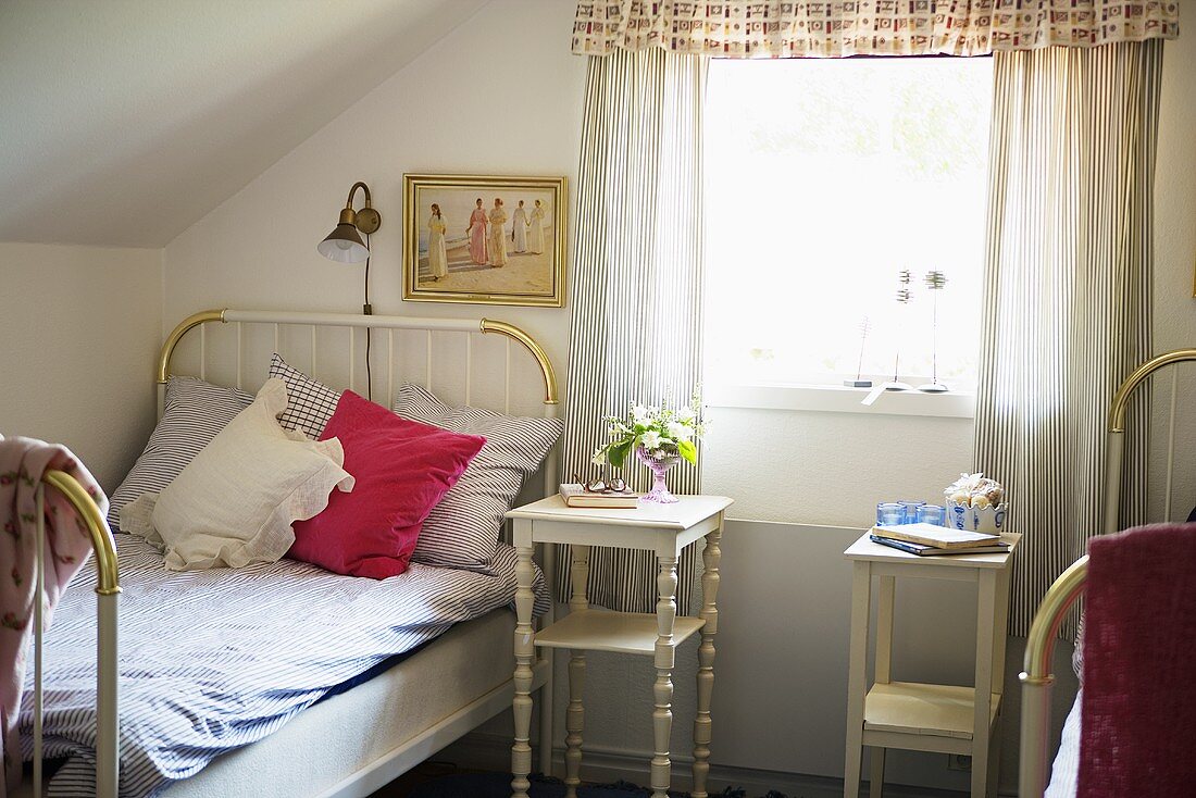 Attic room in a country house with single bed and white night stand