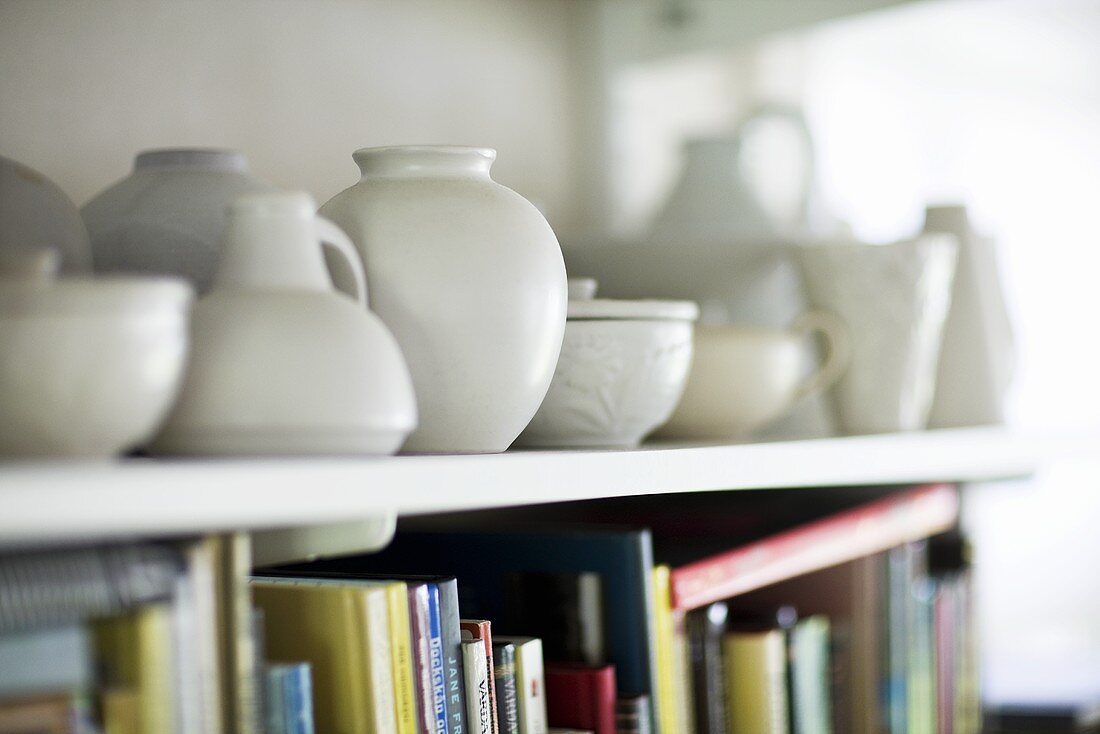 White vases and jars on a white shelf