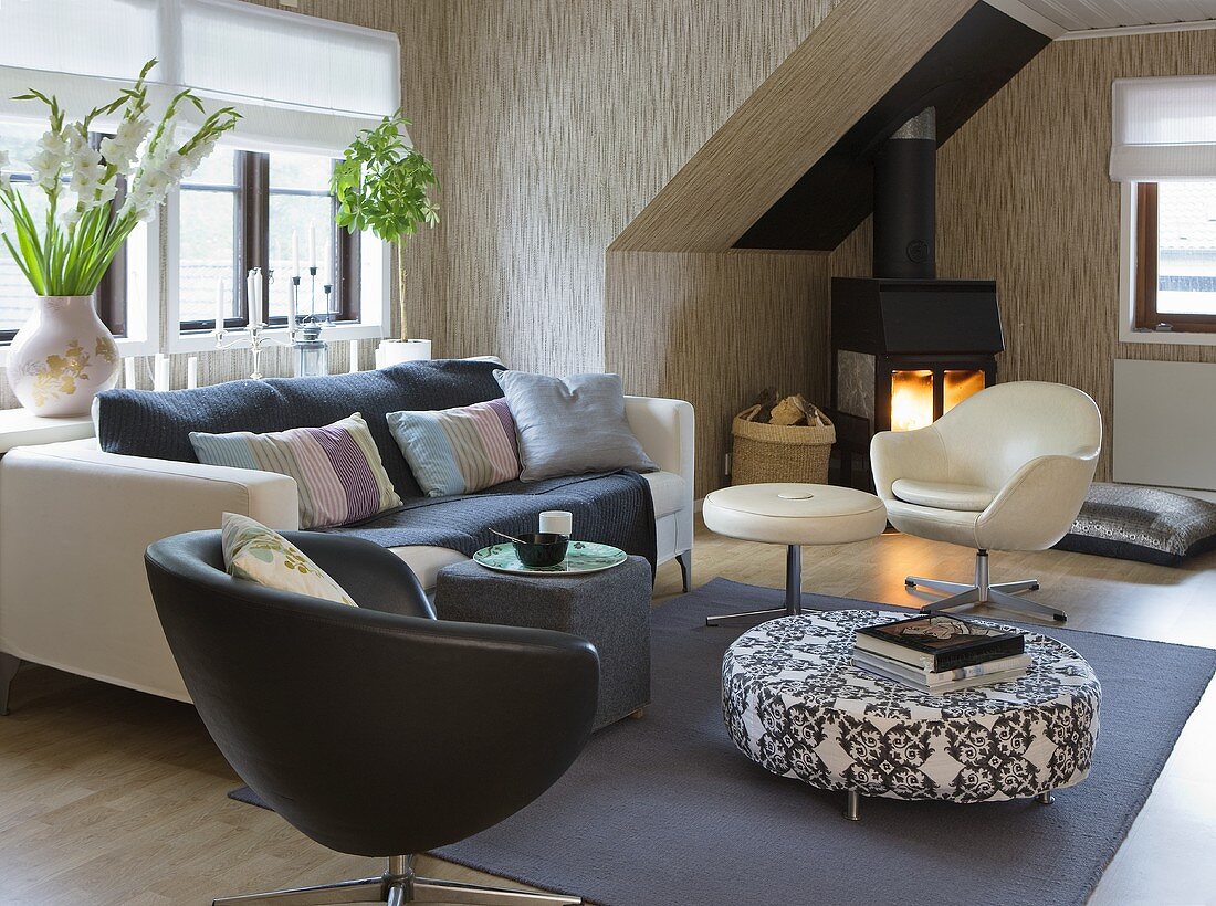 Club chairs, a sofa, a pouffe and a fireplace in a living room