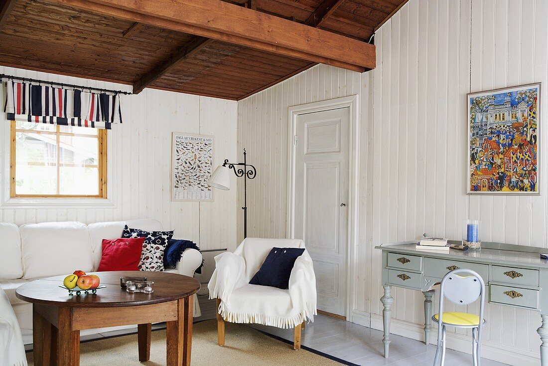 Ländliches Wohnzimmer mit weisser Holzverkleidung und Holzdecke