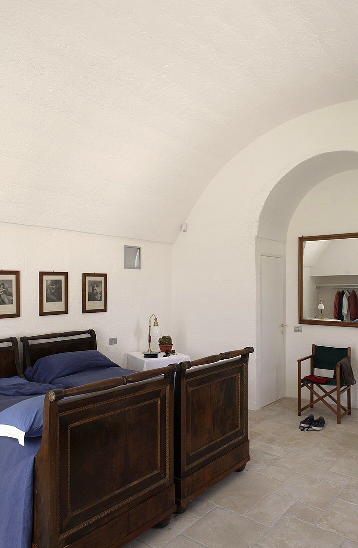 Vaulted ceiling in a bedroom with antique wooden beds