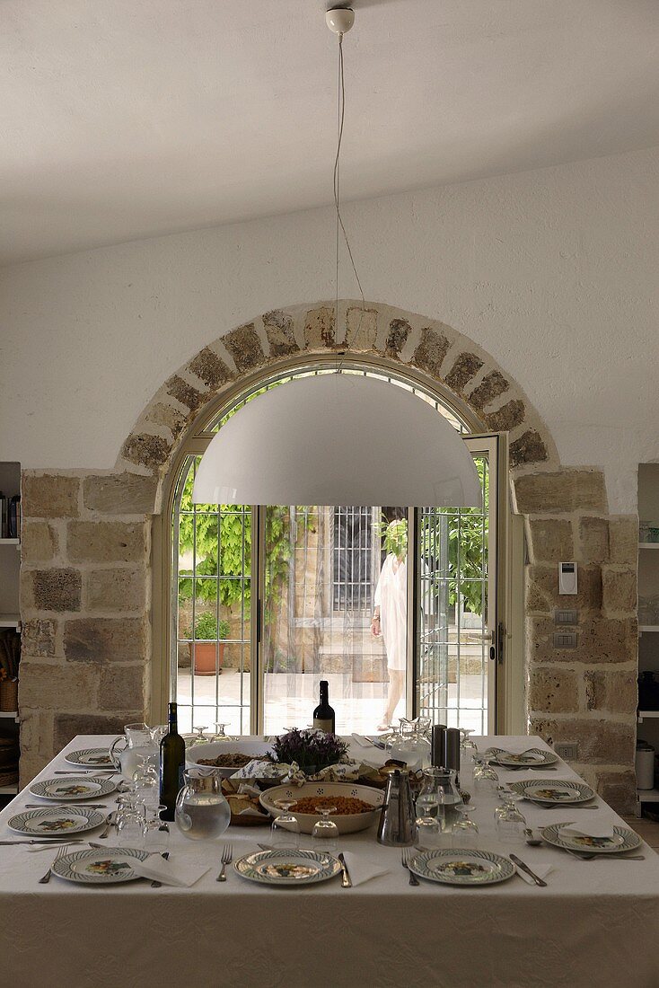 Table set for a party in front of a window a tiled round arch