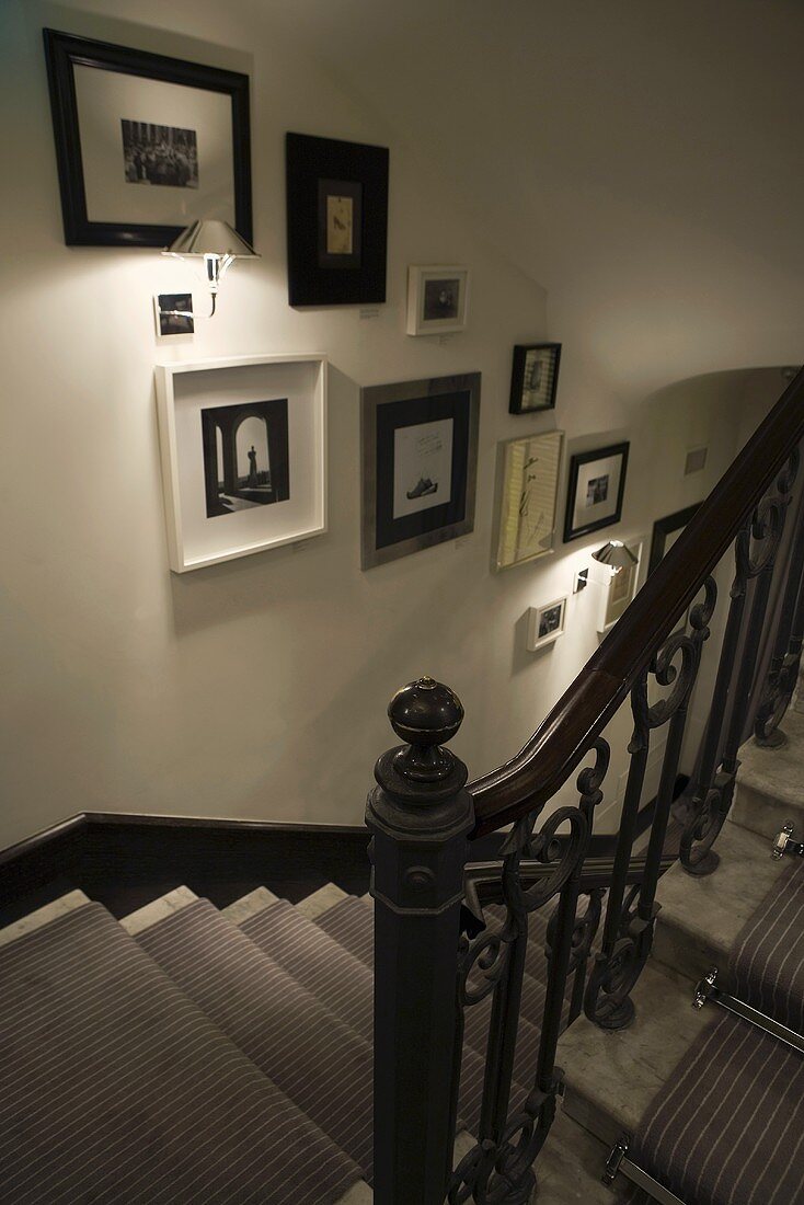 Treppenaufgang mit Wandbeleuchtung und Bildersammlung