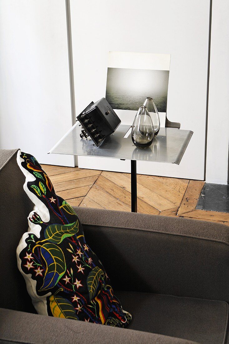 Lounger in front of a side table with a stainless steel top and glass vases