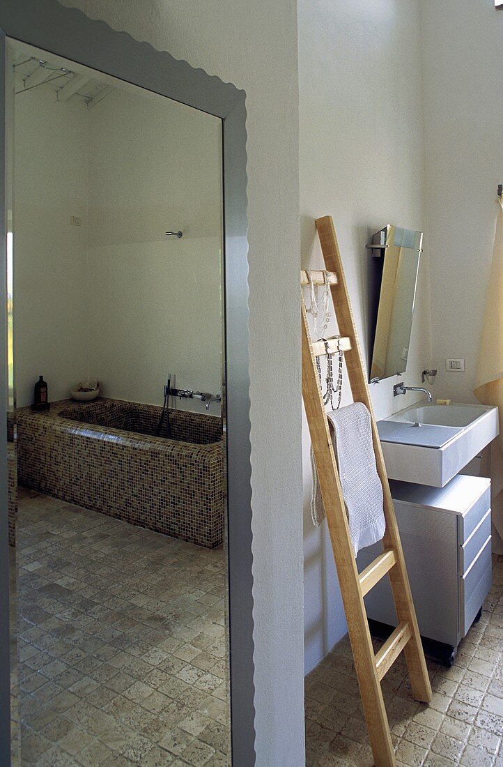 Badezimmer mit Wandspiegel und angelehnter Holzleiter