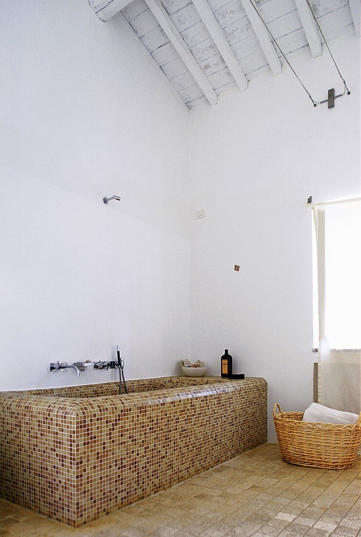 Badewanne mit braunen Mosaikfliesen im Dachraum