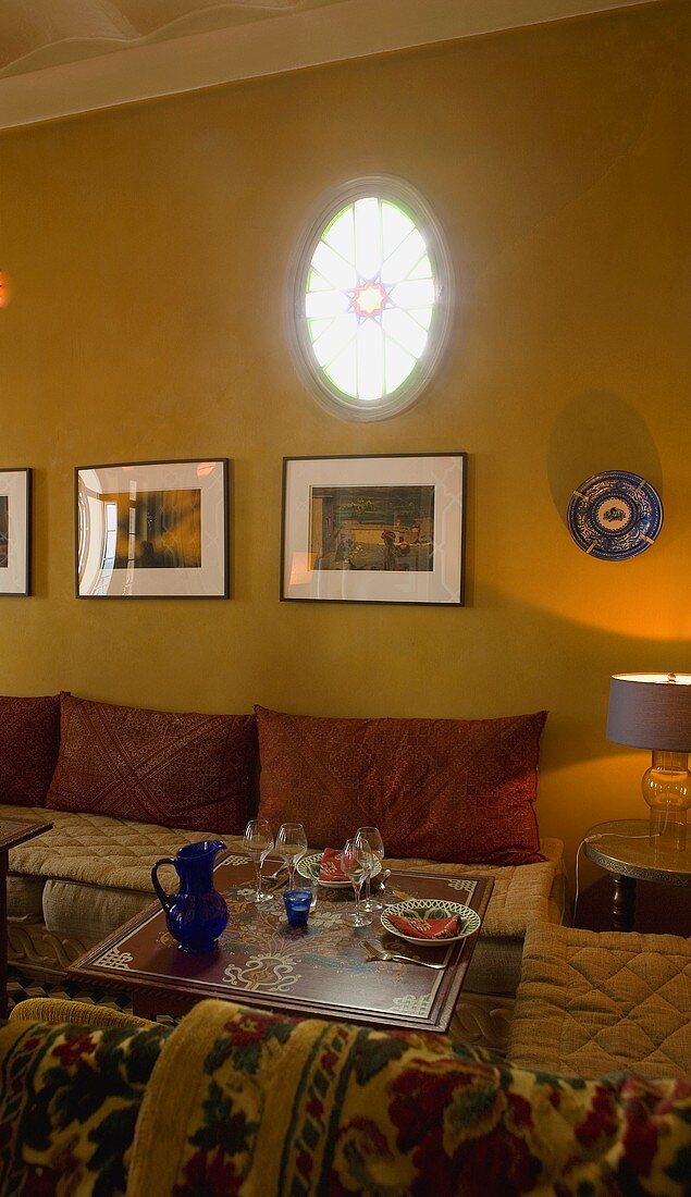 Mood lighting in a Moroccan living room with pillows and upholstered seating around a side table