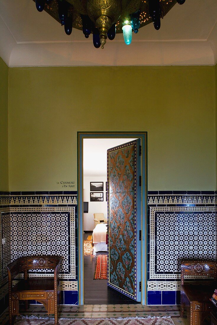 Moroccan lobby with a blue patterned tiles and open door