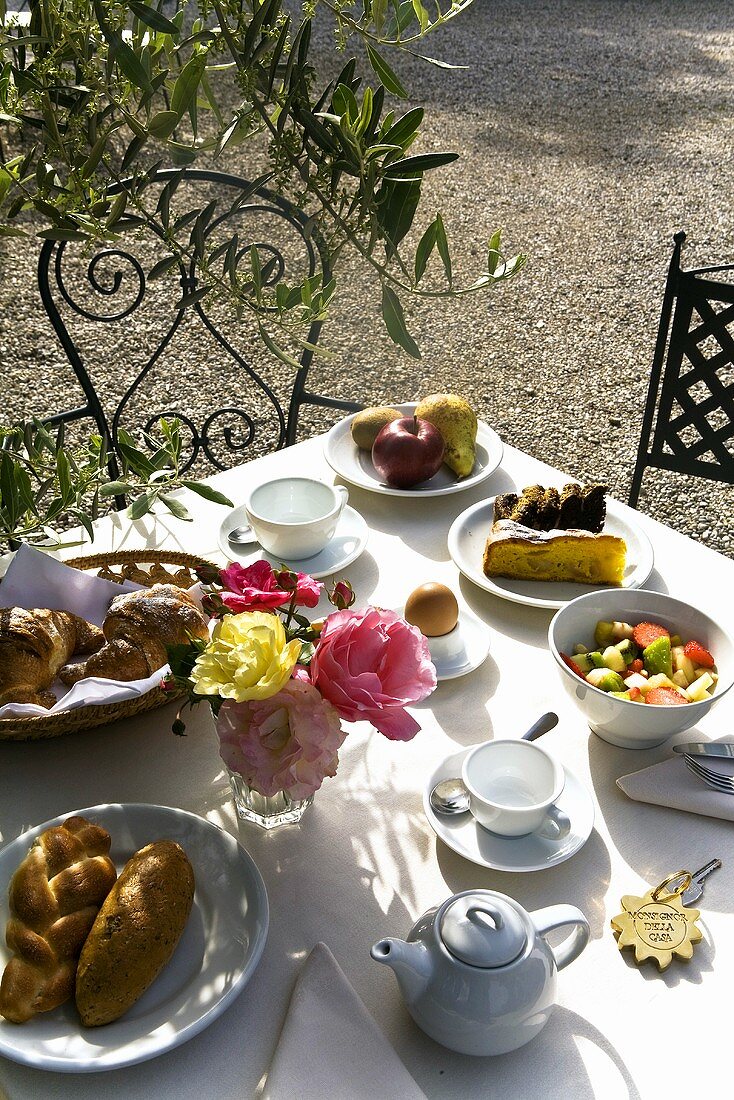Frühstücksgedeck auf Tisch in Freiem mit Sonnenstimmung