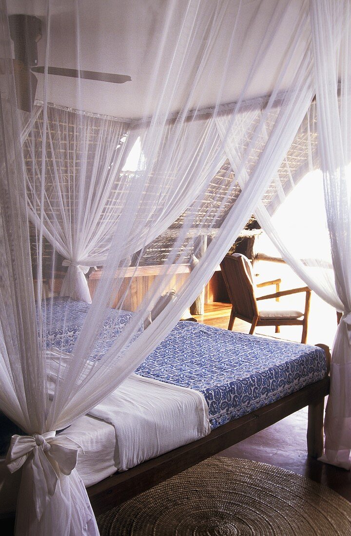 Elegantes Himmelbett mit Baldachin und gerafftem transparenten Vorhang