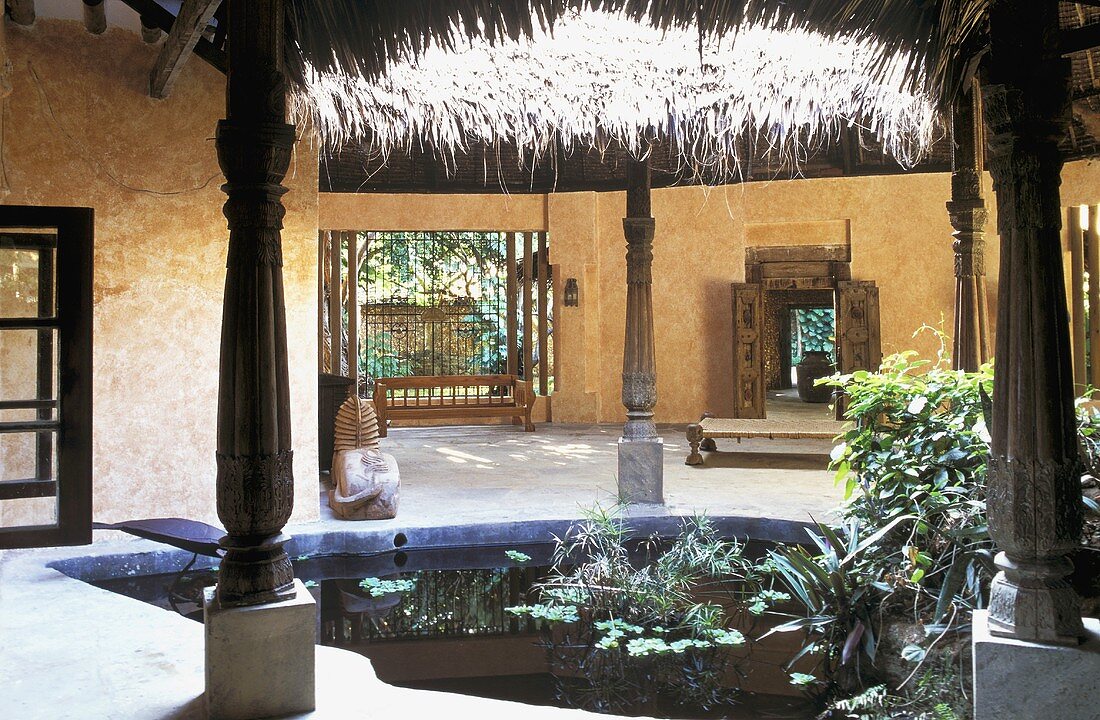 Courtyard with a pond in a African house with a straw roof