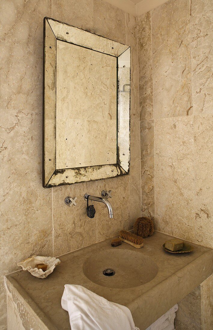 Tiled corner of a bathroom -- stone vanity with framed vintage style mirror