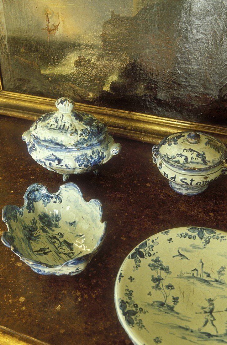 Altes Porzellan mit weiss-blauer Bemalung auf Steinablage im Vintagestil