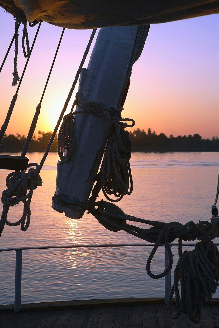 View through a sailboat's rigging of a red sunset, Nile, Egypt