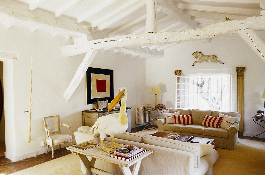 Living room with a sofa suite in a converted attic and white beam construction ceiling