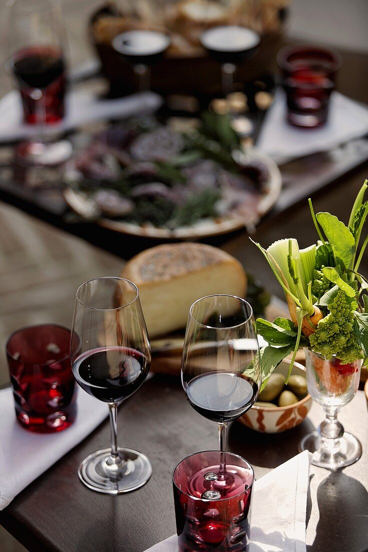 Red wine glasses and starters on a decorated table