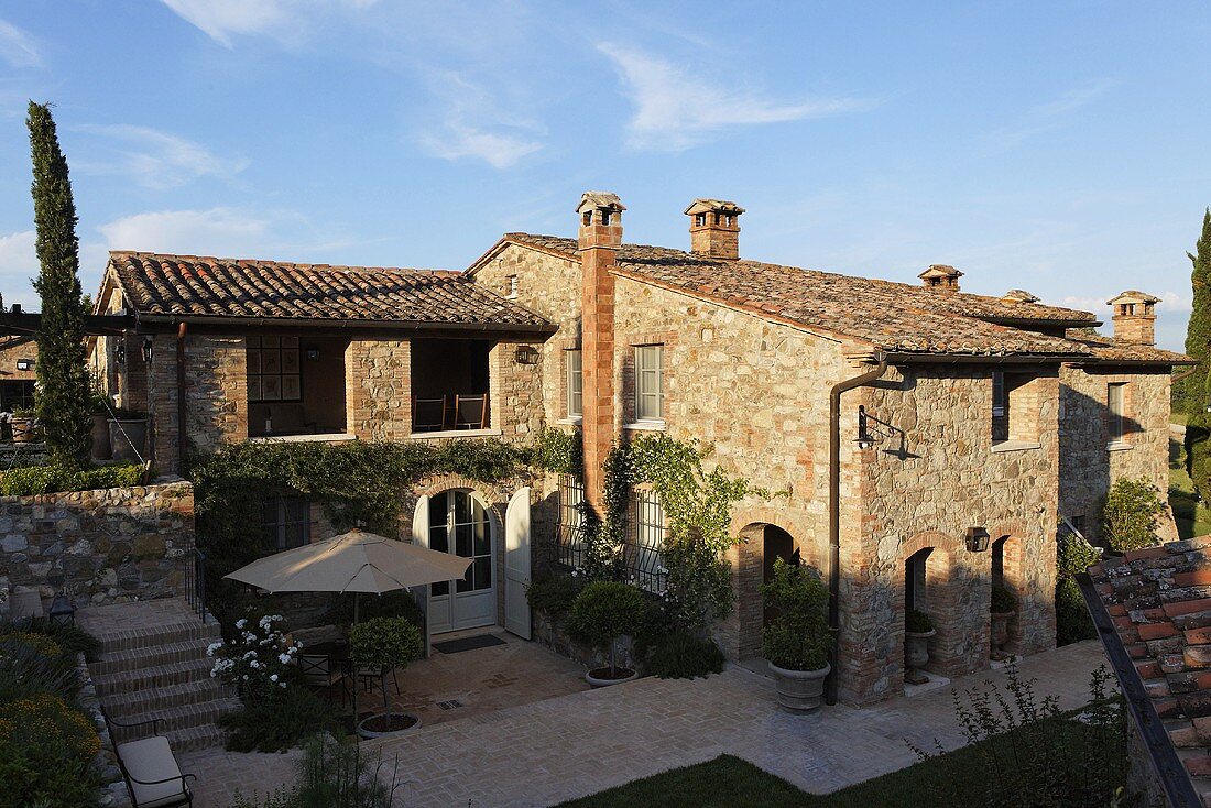 Blue sky above a Mediterranean villa with a natural stone facade and terrace