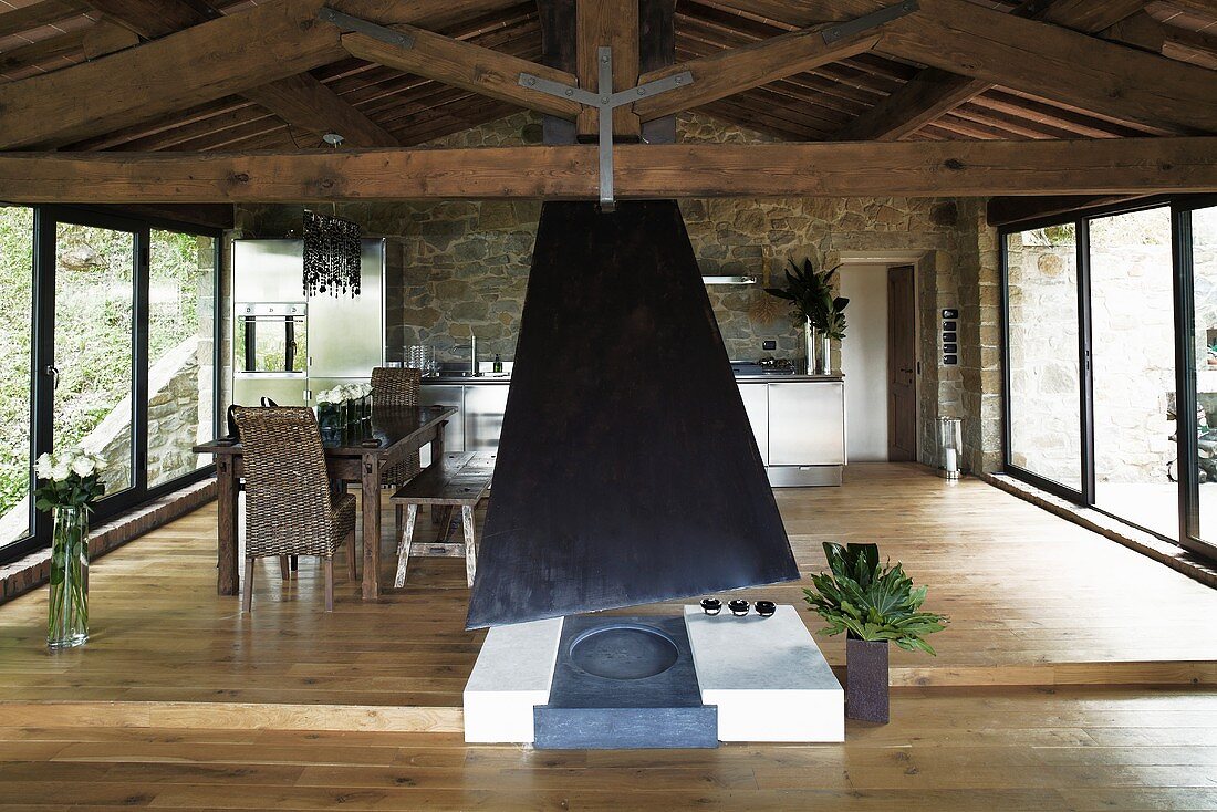 Open fireplace in the living room of a renovated country home with a raised dining area