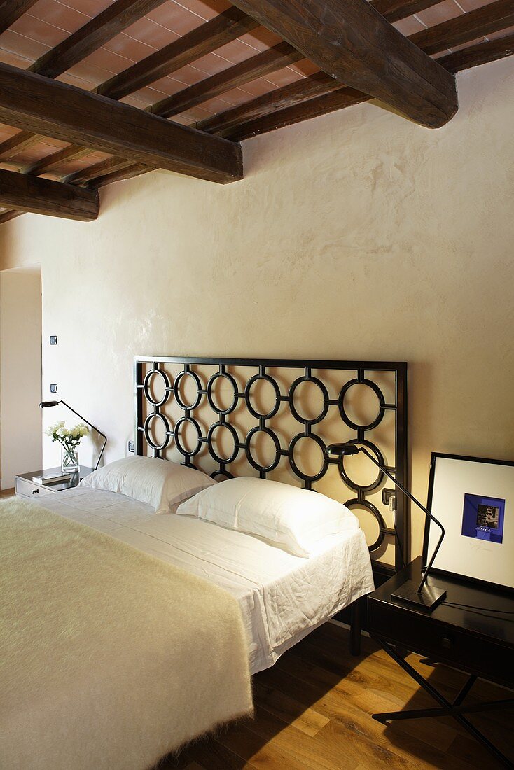 Renoviertes Landhaus - Bett mit Kopfteil aus schwarzem Metallgitter im eleganten Schlafraum