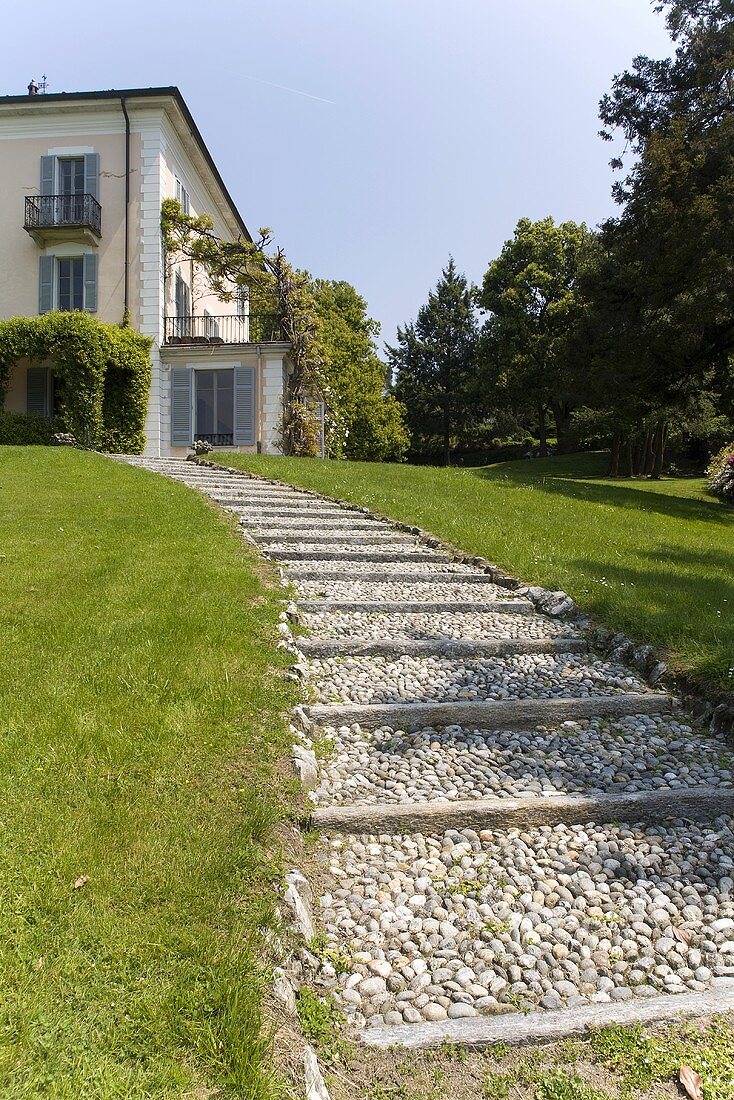 Gravel path through a garden and an elegant villa