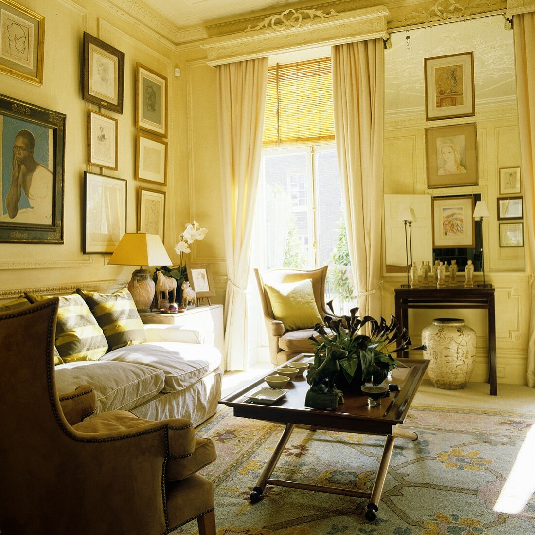Wohnraum einer Villa mit raumhohem Fenster und Couchtisch mit Sofa vor Bildern an Wand