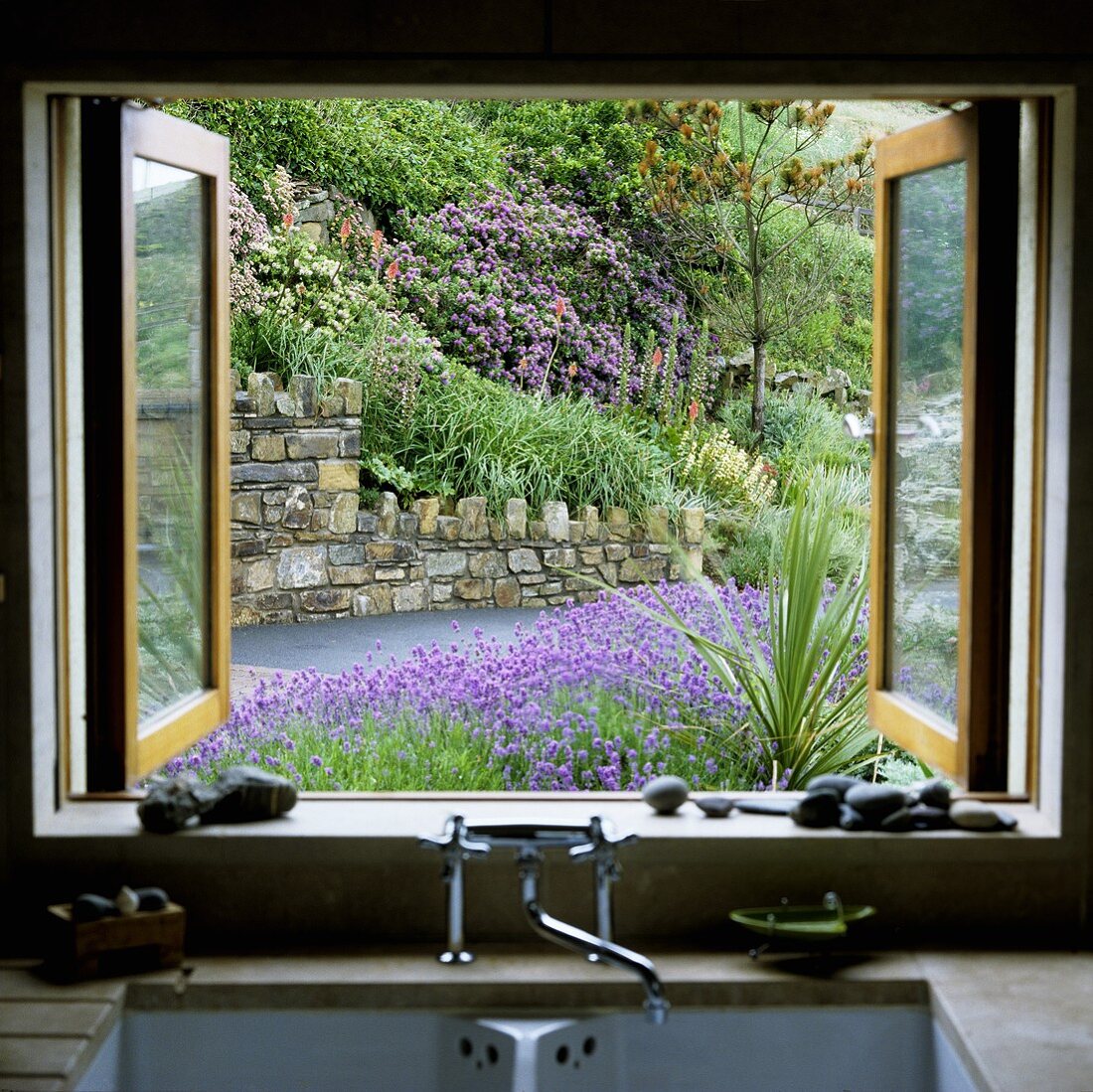 Blick vom Küchenfenster auf blühenden Blumen im Garten