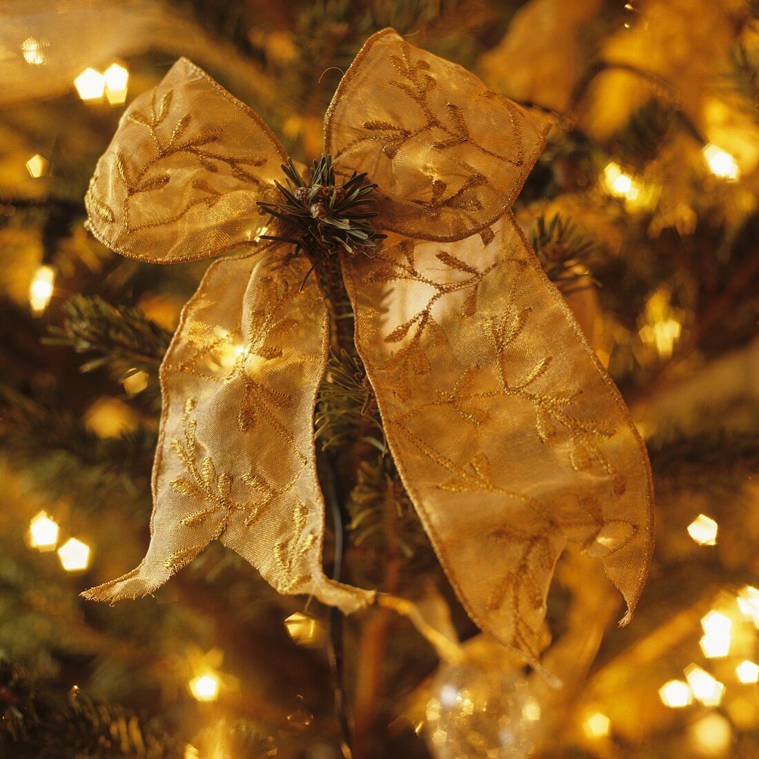A gold embroidered bow on a Christmas tree