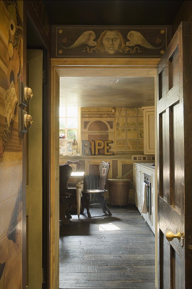 A foreboding atmosphere in the corridor of an apartment with a view through an open door into a country house-style kitchen with a painted wall