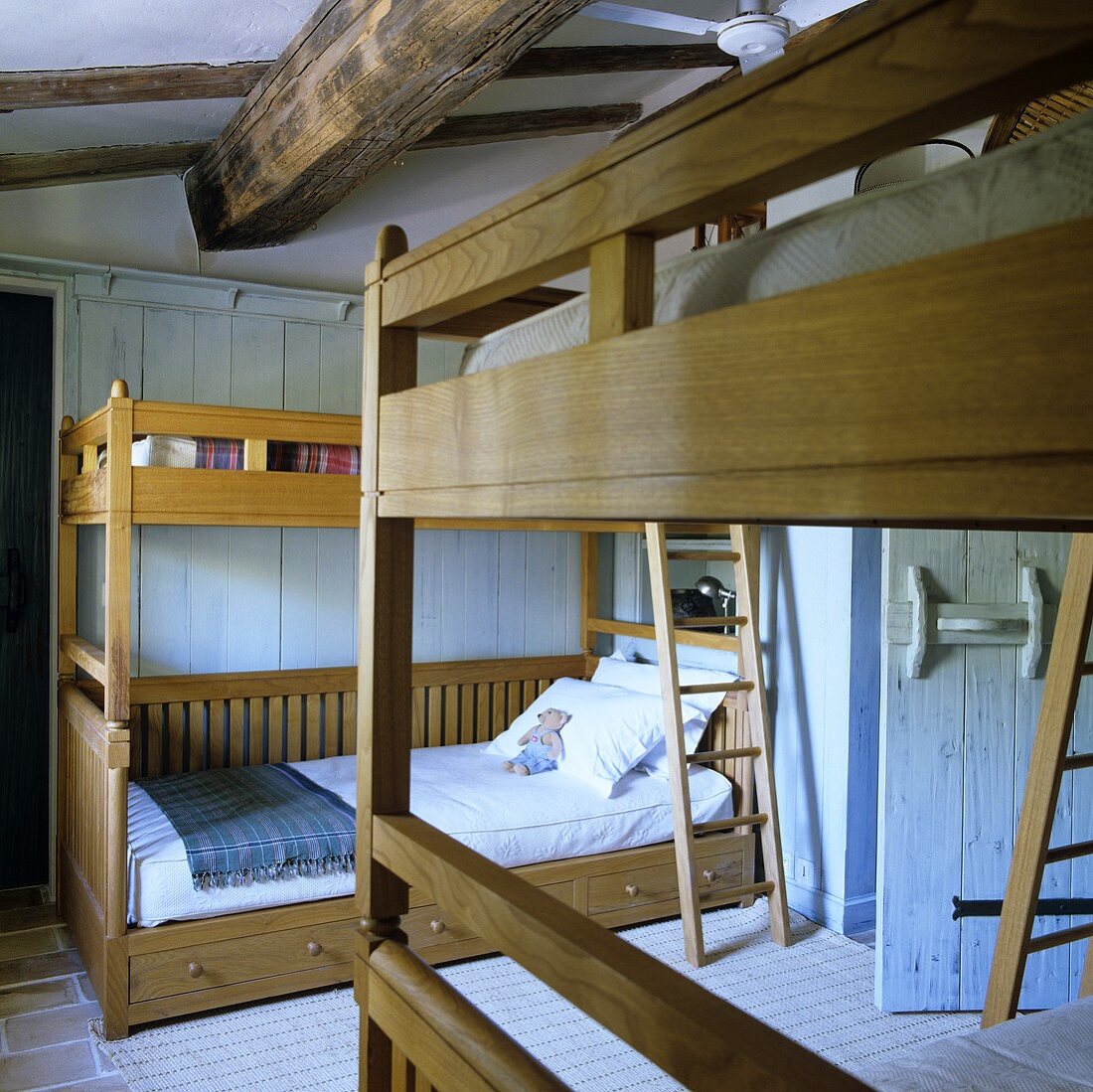 Kinderzimmer mit Stockbetten aus honigfarbenem Holz im rustikalen Landhaus