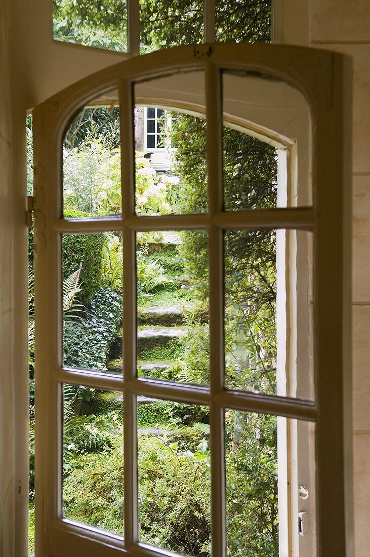 An old glass terrace door with a view into a garden