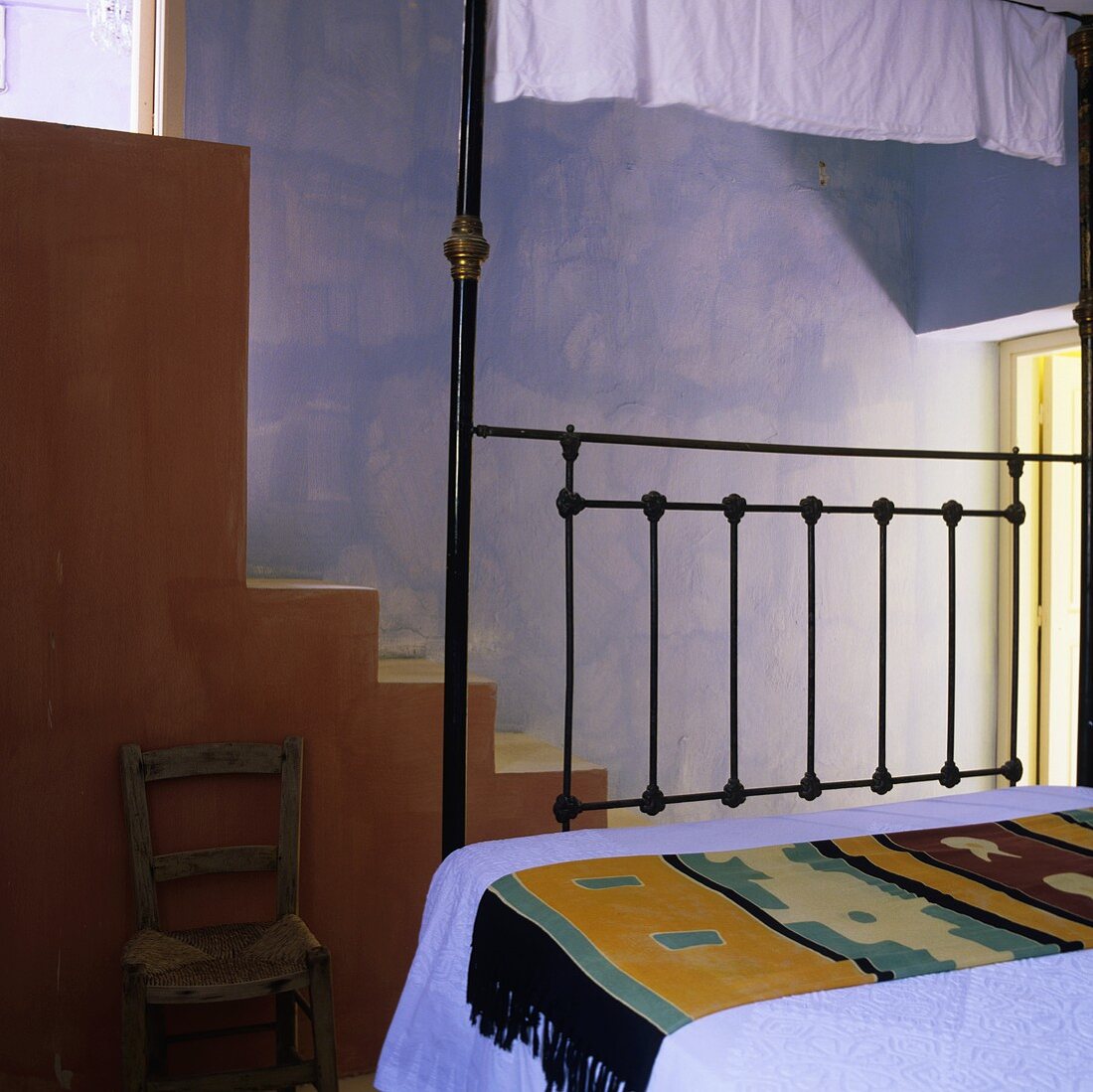 A Mediterranean bedroom with a blue wall and flight of steps