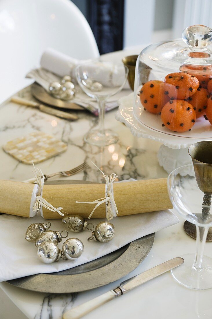 Gedeckter Tisch mit silbernem Weihnachtsschmuck und Tischdeko