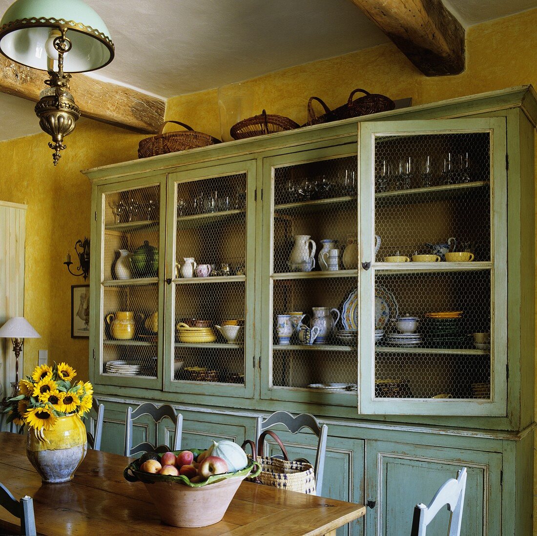 Gelbgetönte Küche mit hellblauem Vintage Geschirrschrank