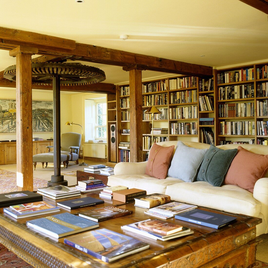 An old English mill house with an open-plan living room and a sofa in front of a long bookshelf