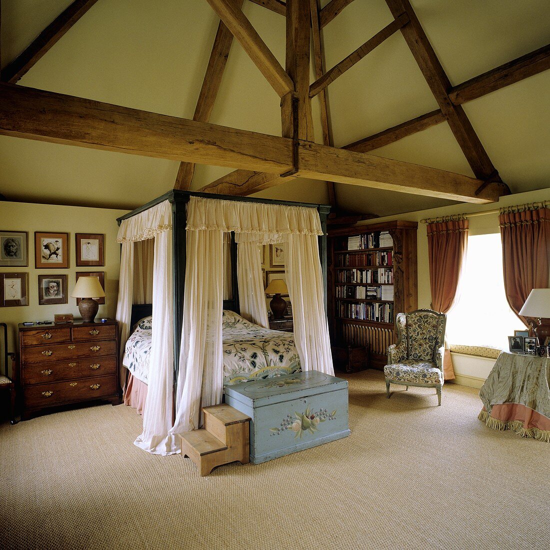 A four poster bed in the attic of a country house with rustic wood beams